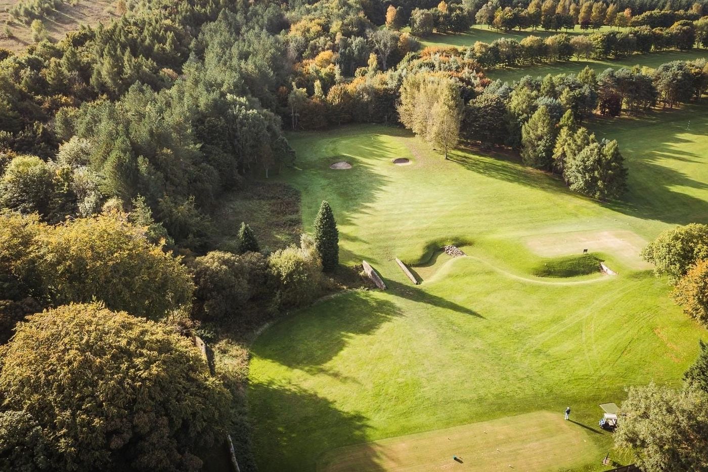An aerial view of a hole at Beamish Park Golf Club, framed by autumn woodland