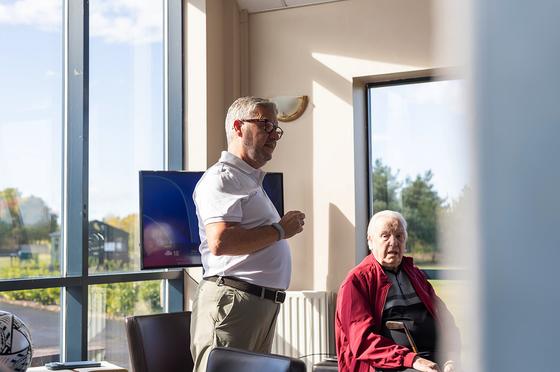 Andrew talking with a guest beside the window