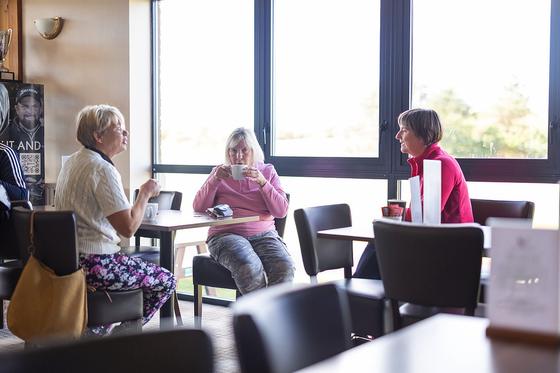 Three women sharing a coffee and a chat